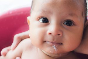 Bebê com refluxo gastroesofágico infantil vomitando depois de um banho
