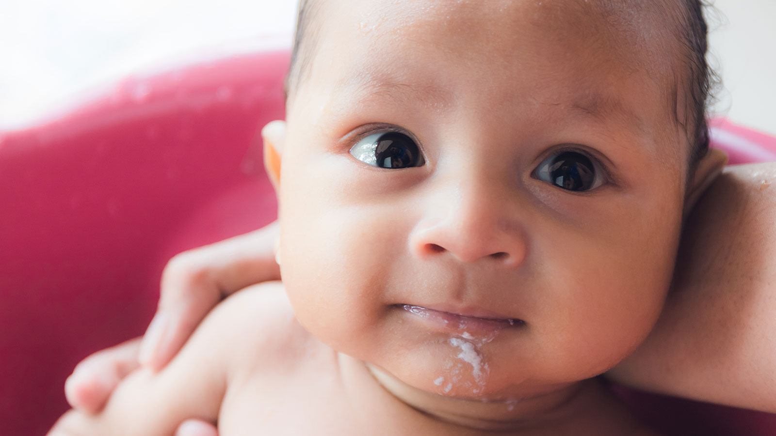 Bebê com refluxo gastroesofágico infantil vomitando depois de um banho